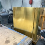 Custom detailed brass kitchen hood in the metal finishing rooms - RBL Metals -