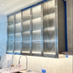 Custom brushed stainless steel and glass ceiling hung upper kitchen Cabinets. All hand made
