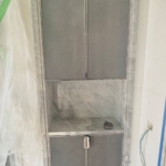 Custom polished stainless steel storage unit in a nyc bathroom RBL made the metal frames integrated framed and leather wrapped panels. All hand made